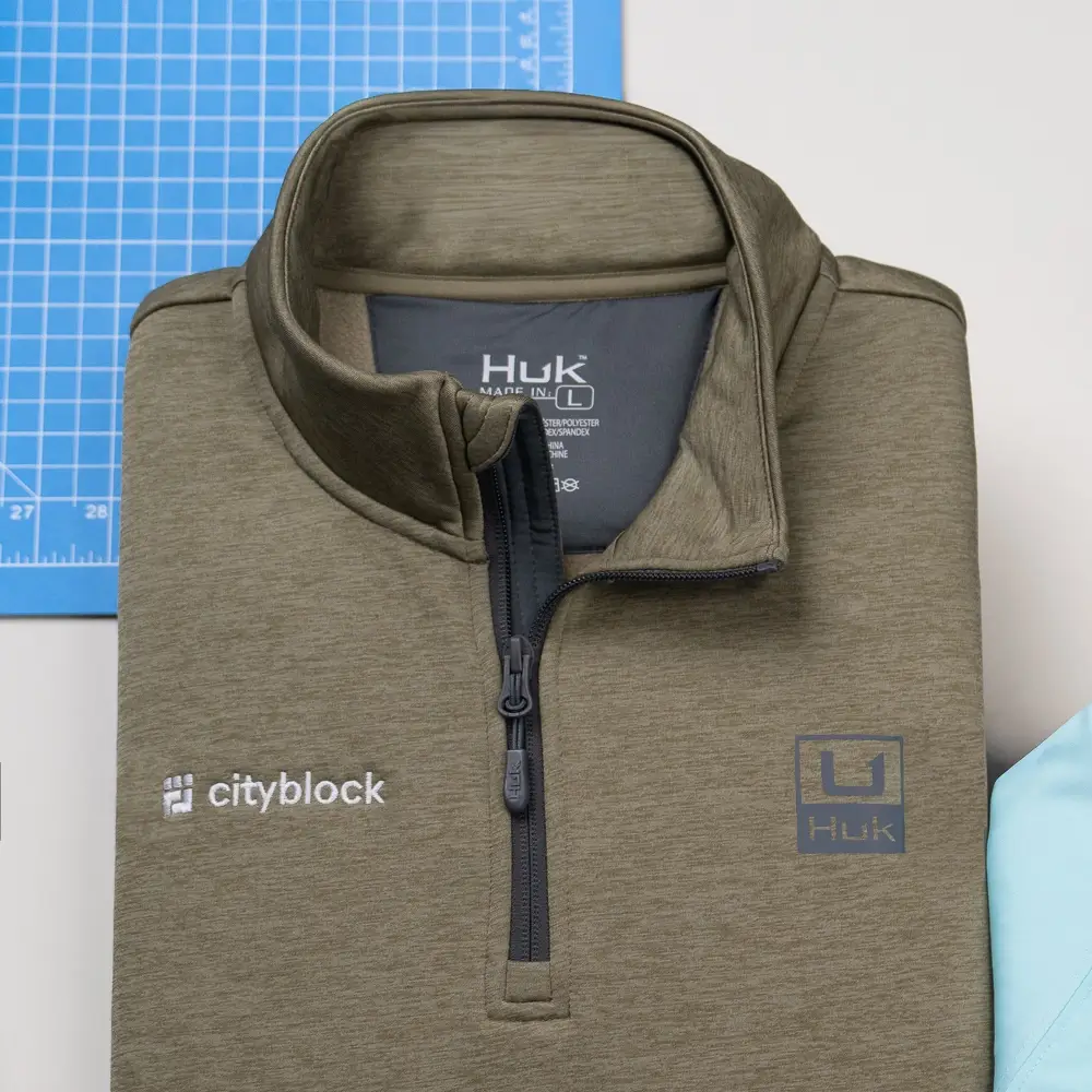 Custom quarter-zips and hats deliver polished logo apparel.